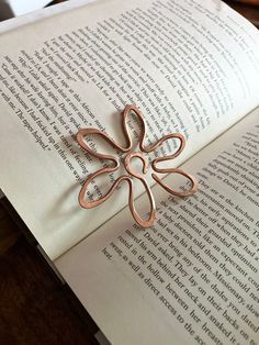 an open book with a metal flower on it