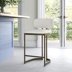 a white chair sitting in front of a counter top next to a potted plant