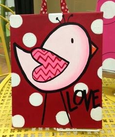 a painting of a bird on a red and white polka dot bag with the word love painted on it