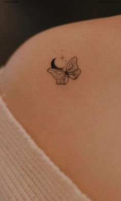 a small butterfly tattoo on the back of a woman's left upper half arm