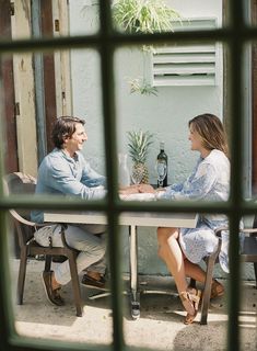 a man and woman sitting at a table talking