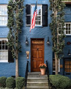 a blue house with an american flag on the front door and steps leading up to it