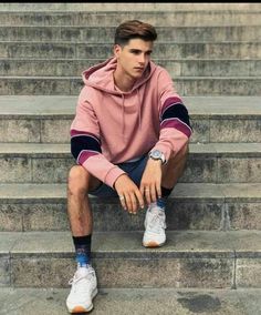 a young man sitting on the steps with his foot up and looking at the camera