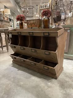 an old wooden display case with drawers and vases on the shelves in a store