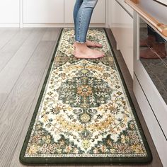 a woman standing on top of a rug in a kitchen