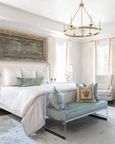 a bedroom with a bed, chair and chandelier hanging from the ceiling in front of two windows