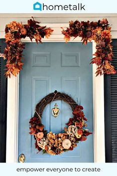 a blue front door with a wreath on it and two pumpkins hanging from the side