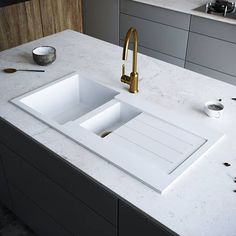 a kitchen sink sitting on top of a white counter