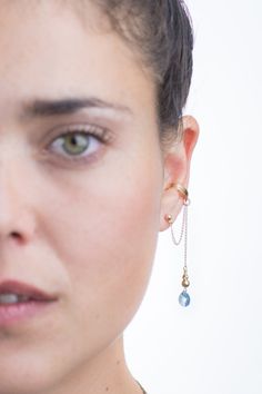 "This gold ear cuff drop dangle earring is handmade in our own original and exclusive design to give you that special feeling of wearing a one of a kind statment piece. Made with a faceted pear shape Swarovski crystal with a gentle light blue hue, dangling from a 14K gold filled chain, this ear cuff is suitable for any age and can fit any casual or elegant look. No piercing is required to wear our unique ear cuff jewelry, the cuff is easily and comfortably placed around the cartilage using an ad Unique Ear Cuffs, Ear Wraps, Crystal Ear Cuff, Ear Cuff Jewelry, Cuff Earring, Jewelry Swarovski, Wrap Earrings, Gold Ear Cuff, Cuff Jewelry