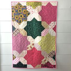 a colorful quilt hanging on the wall