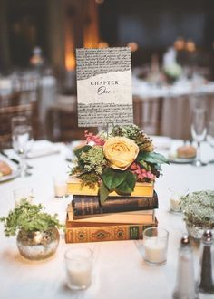 a table topped with books and flowers on top of each other