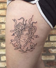 a woman's thigh with a tattoo design on it