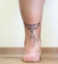 a woman's foot with a small tattoo on the top and bottom part of her leg