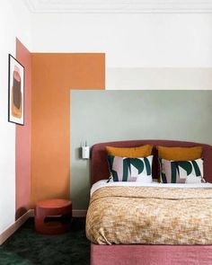 a large bed sitting in a bedroom next to a wall with paintings on it's sides