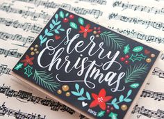 a merry christmas card sitting on top of sheet music