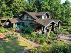 an aerial view of a house surrounded by trees and plants in the foreground, with lots of greenery on either side