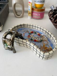 a white table topped with a blue plate filled with jewelry