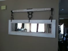 an old window is hung on the wall in front of a mirror with two handles