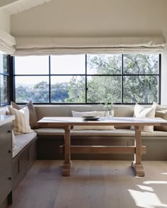 a living room filled with furniture and large windows