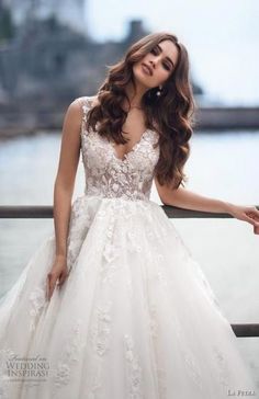 a woman in a wedding dress leaning on a rail with her hand on her hip