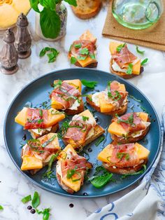 a blue plate topped with slices of bread covered in prosciutto