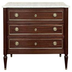 an antique chest of drawers with marble top