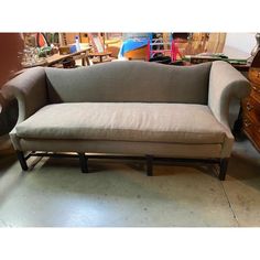 a couch and footstool in a room with other items on the floor behind it