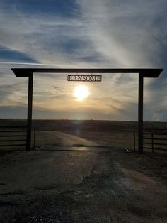 the sun is setting over an open field with a sign that reads, namomah