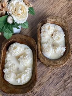 two carved wooden bowls with flowers in them