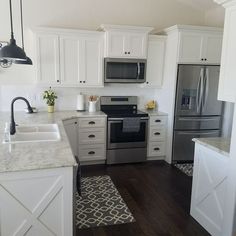 a kitchen with white cabinets and stainless steel appliances