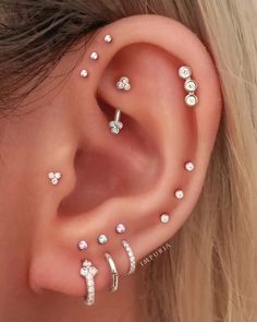 a woman's ear with several piercings on it