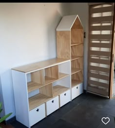 an empty room with shelves and drawers on the floor, next to a wooden door