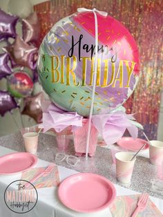 a birthday party with balloons, plates and cups