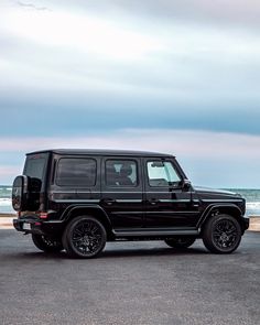 a black mercedes benz parked on the beach