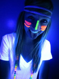 a woman with long hair wearing neon lights on her face and holding a cell phone