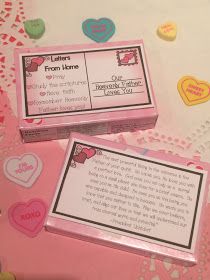 two pink boxes sitting on top of a table covered in hearts and confetti