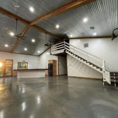 an empty room with some stairs and lights on the ceiling is shown in this image