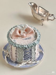 there is a cake on the plate and a silver spoon next to it with a pink bow