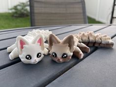 three small ceramic figurines sitting on top of a wooden table next to each other