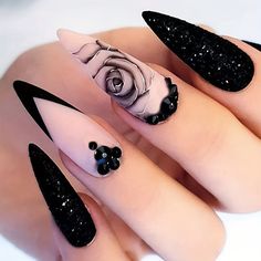 black and white stiled nails with flowers on them, one has a rose in the middle