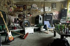 a room filled with lots of guitars and musical equipment on the wall next to each other