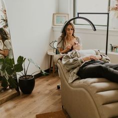 a woman sitting on a couch in front of a mirror