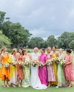 a group of women standing next to each other in dresses