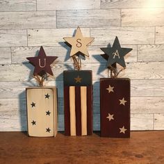 three wooden blocks with stars on them and the letters u, s, and f