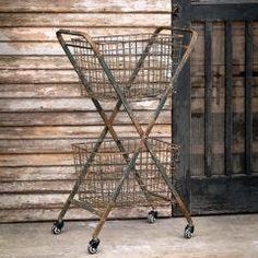 an old metal basket sitting on top of a wooden floor next to a door with shutters