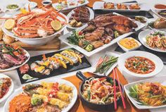 a table filled with different types of food on plates and serving utensils next to each other