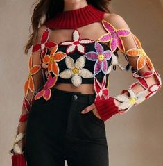 a woman is wearing a crop top with flowers on it