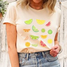 a woman wearing a t - shirt with fruit slices on the front and side,