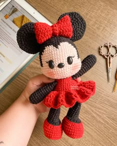 a crocheted mickey mouse doll next to a pair of scissors