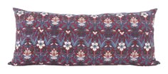 a red and blue pillow with white flowers on the front, sitting on a white background